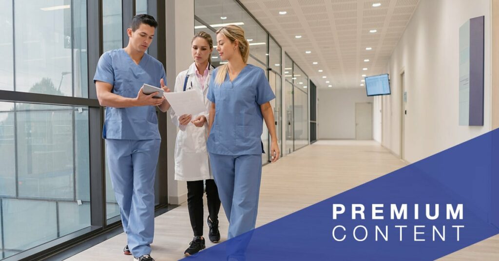 Medical residents showing something to female doctor on tablet while walking at the hospital