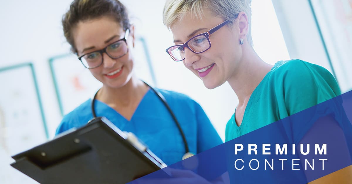 Close up view of two professional nurses with eyeglasses checking the patient papers in a doctors office.