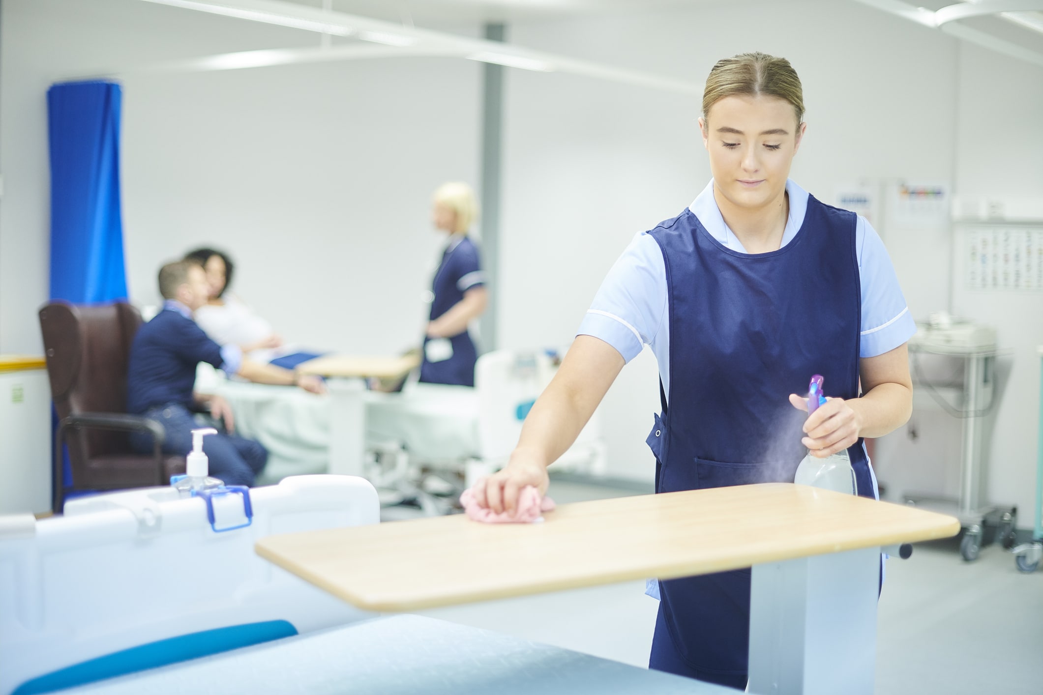 Nurse cleaning off bedside table