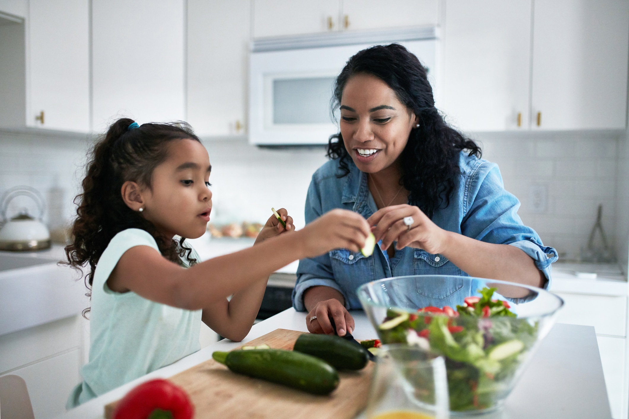 Mother and daughter preparing a salad