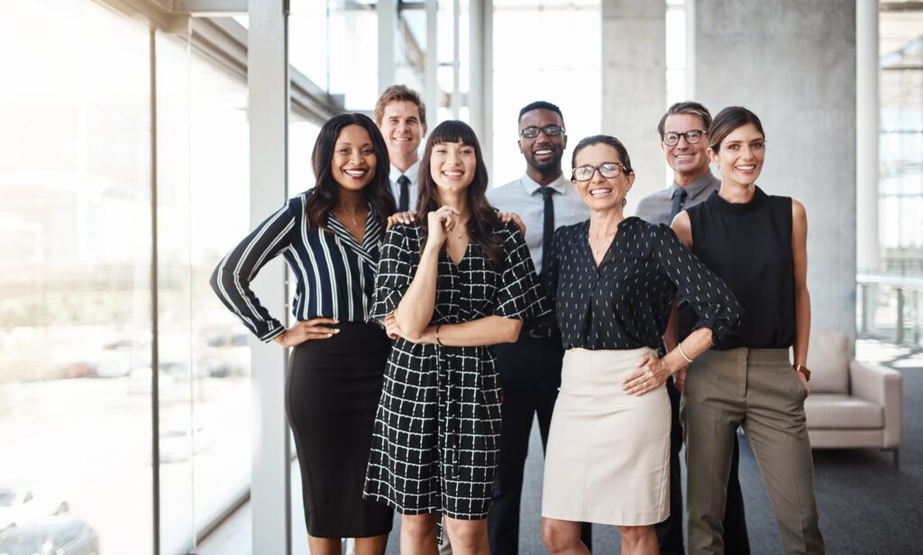 Smiling group of office workers standing next to a window