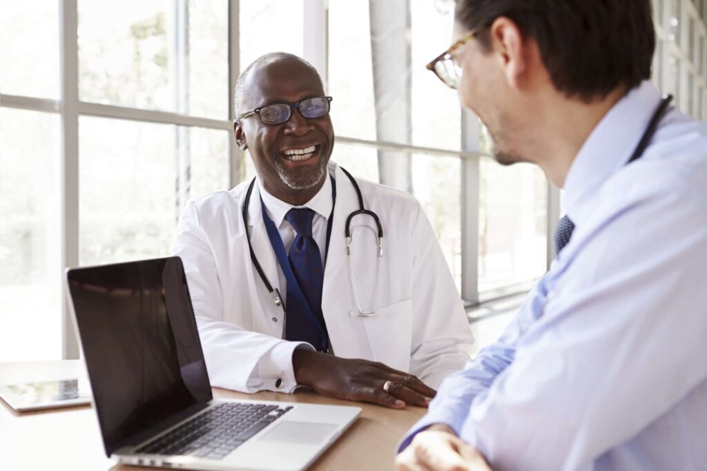 Two senior healthcare workers in consultation laughing