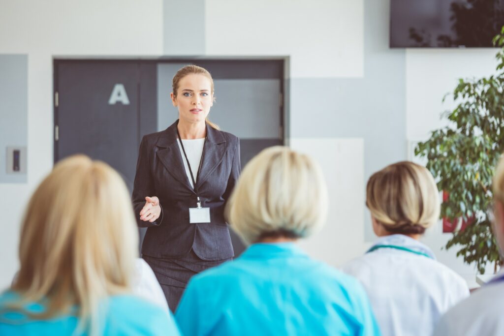 Healthcare consultant speaking to a group of doctors and other healthcare professionals