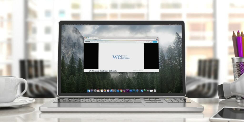 Laptop on desk with “We Measure Healthcare Differently” video pulled up