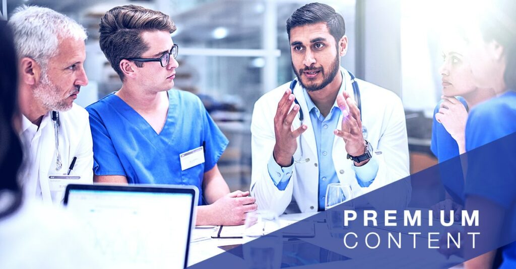 Doctor speaking to a group of other doctors and nurses at a table