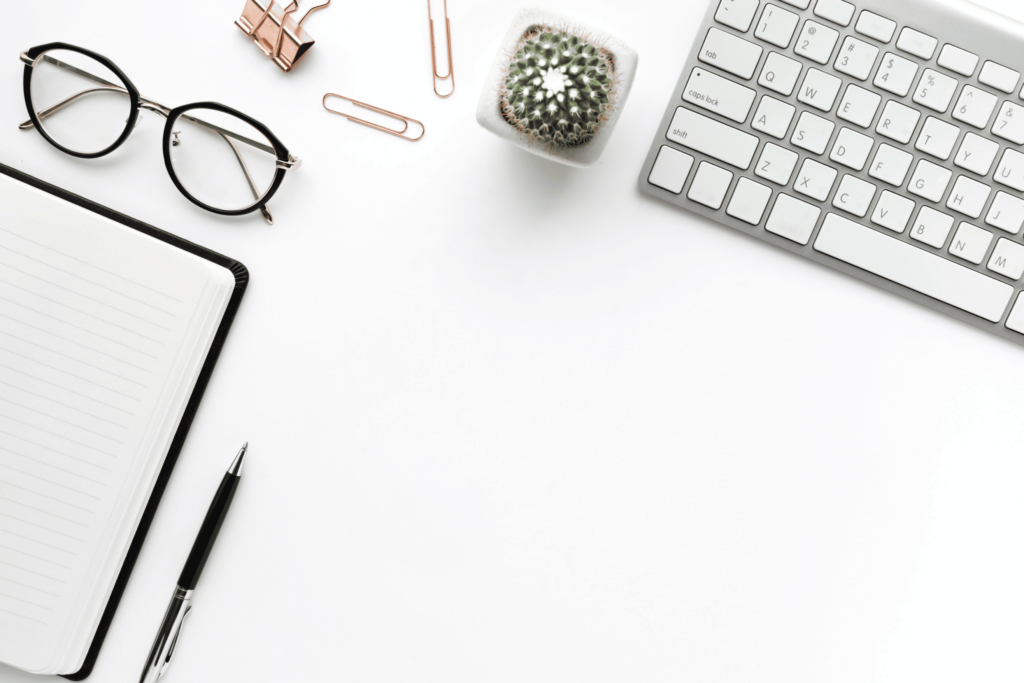 Business desk with office supplies on white background.