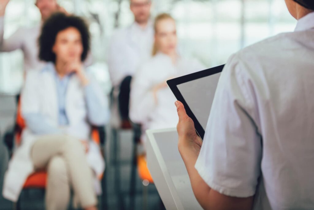 Medical professional leading care teams with a tablet