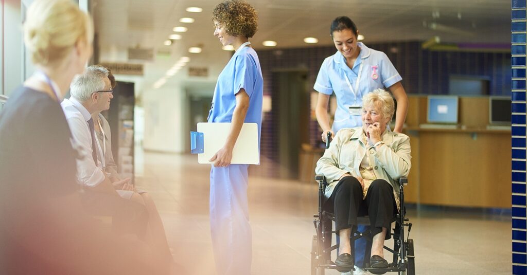 Nurse pushing patient in wheelchair at hospital