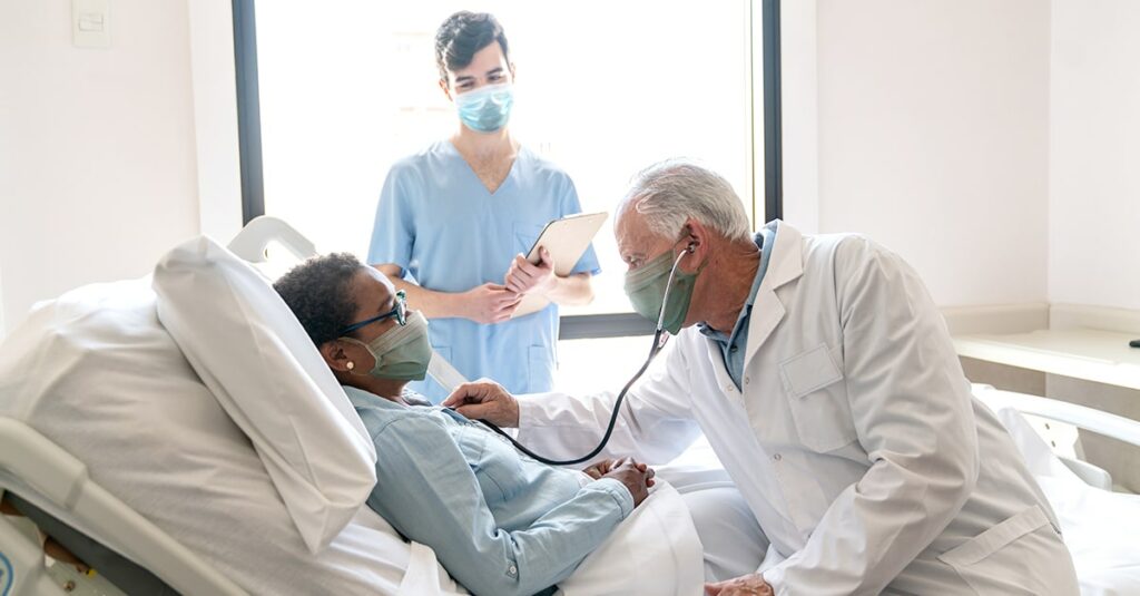 Masked doctor and nurse treating patient