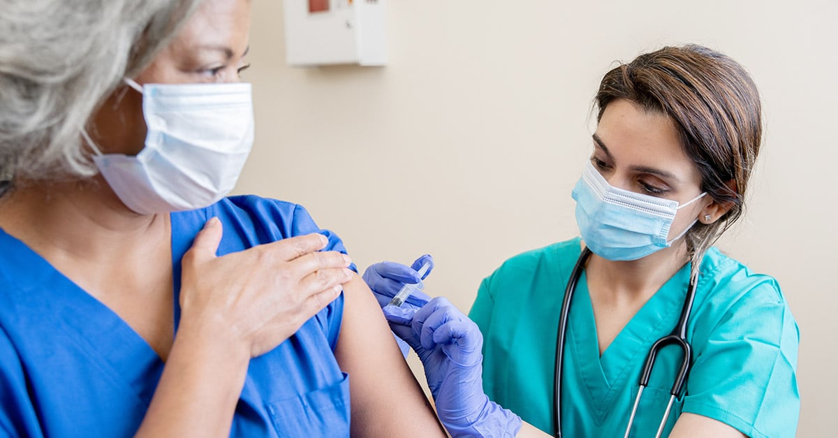 Nurse administering COVID-19 vaccine to patient