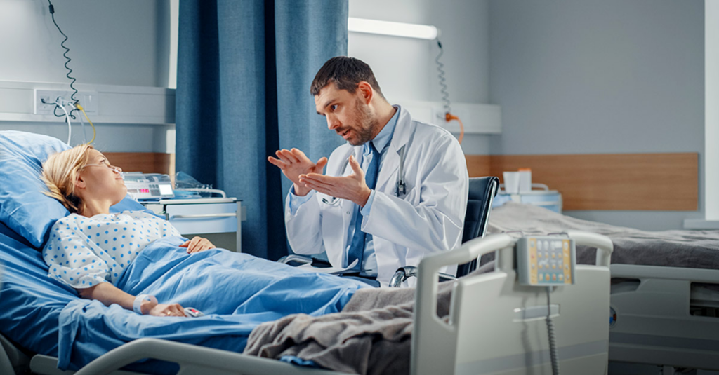 Doctor speaking to patient in hospital bed