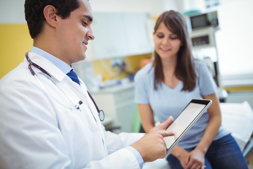 Doctor using digital tablet to improve patient experience