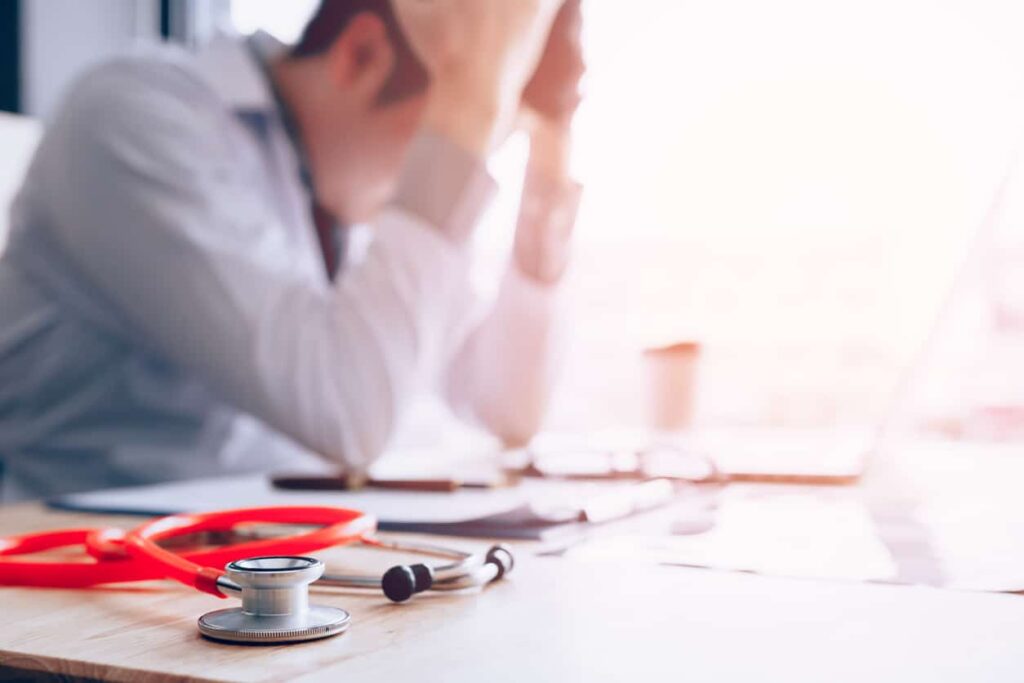 physician emotionally exhausted at desk