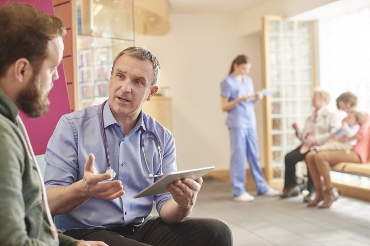 doctor speaking to patient in waiting room