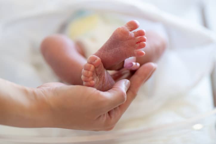 nurse holding up infant's feet