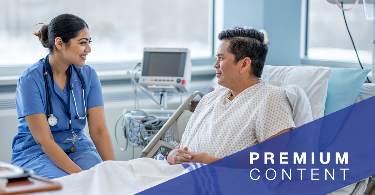 Patient speaking with healthcare worker in hospital bed.