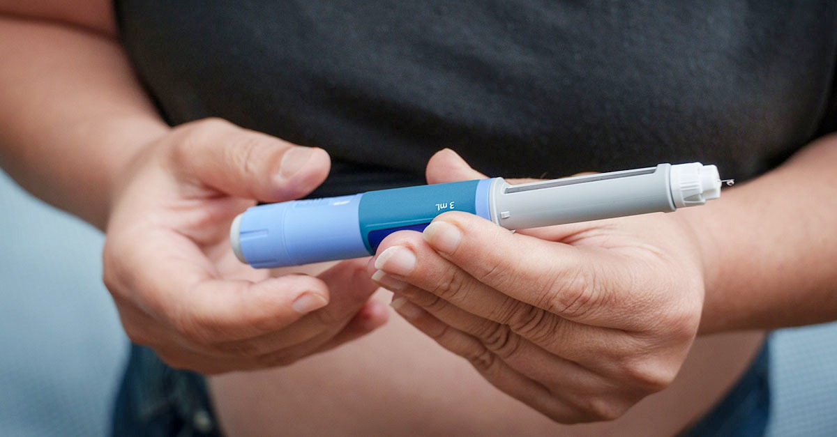 adult holding GLP-1 injection